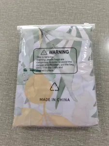 Vue détaillée du rideau de douche floral en polyester imperméable emballé dans un sac plastique.