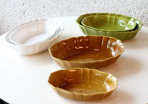 Detailed view of retro ceramic oval baking dishes with wavy edges in various colors and sizes.