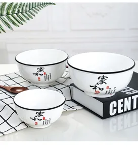 Primo piano del set di ciotole di riso in ceramica con bordi neri e testo tradizionale cinese.
