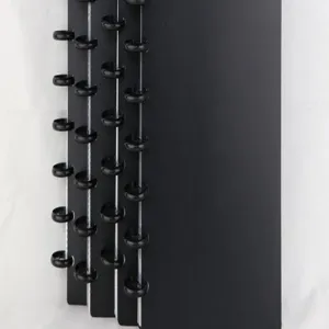 Close-up detail of black disc-bound card binder with mushroom holes for photo storage.