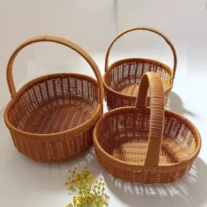 Set of three brown woven wicker storage baskets with handles for picnic, shopping and home use.