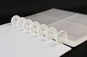 Close-up of white discbound photocard binder with heart mushroom rings and clear pocket pages.