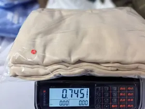 Detailed view of women's fleece lined hooded sweatshirt and loose sweatpants set in neutral tone.