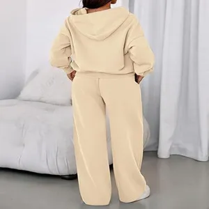 Detail view of the beige fleece hoodie and wide leg sweatpants lounge set, cozy indoor look.