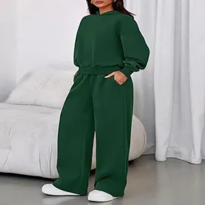 Detailed view of the dark green cozy fleece hoodie and wide-leg sweatpants set indoors.
