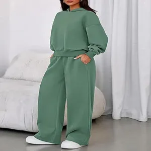Close up view of the green hooded sweatshirt and wide leg trousers fabric details