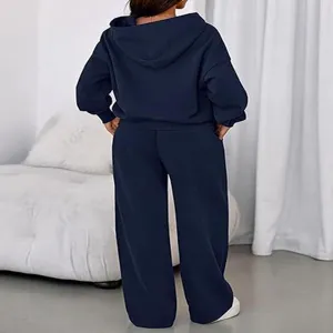 Back view detail of the cozy navy blue hoodie and wide leg sweatpants tracksuit set indoors.