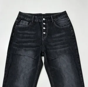 Distressed black denim pants detail shot, showing multi-button fly and washed finish.