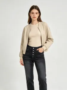 Stylish women's distressed high-waist multi-button black skinny denim jeans paired with jacket.