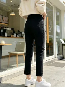 Women black slim fit cropped jeans with raw hem and ripped details, stylish street style.
