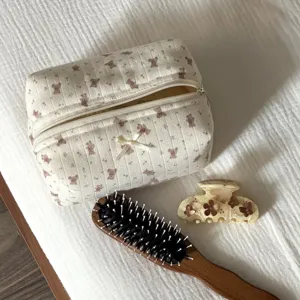Cute bear cosmetic bag detail with matching wooden hairbrush and flower hair claw clip.