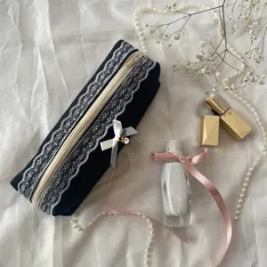 Detailed shot of black lace bow pencil case, cute makeup brush storage bag with elegant lace.