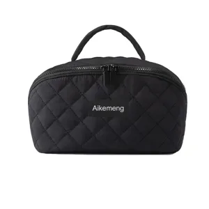 Vue détaillée de la trousse de maquillage matelassée noire avec texture douce et double zips.