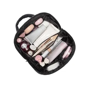 Détail intérieur de la trousse matelassée avec des compartiments organisés pour les cosmétiques.