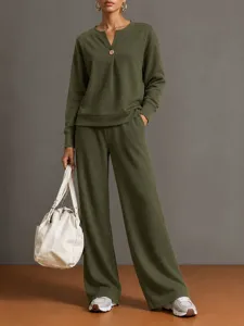 Detailed view of the olive green long-sleeve V-neck sweatshirt and wide-leg trousers set.