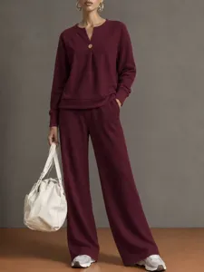 Detailed view of the casual burgundy long-sleeve sweatshirt and wide-leg pants outfit.