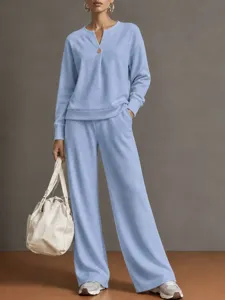 Close-up detail of the light blue V-neck button sweatshirt and wide leg lounge pants set.