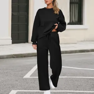 Detail shot of women's black long sleeve sweatshirt and wide leg pants knit set outdoors.