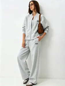 Grey zip up sweatshirt and loose trousers detail view, casual women tracksuit outfit.