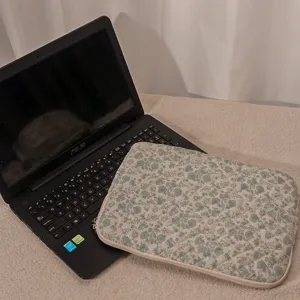 Custodia protettiva trapuntata con fiori per laptop in dettaglio, morbida borsa per 14 pollici.