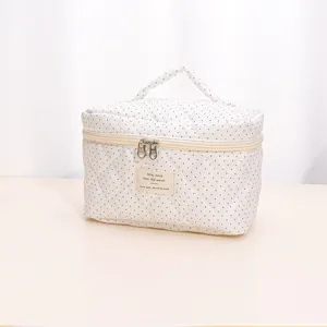 White quilted cosmetic bag with black polka dots, portable handle and practical large storage.