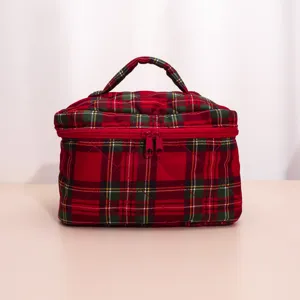 Close-up detail of the red and green plaid quilted cosmetic bag showing neat stitching.