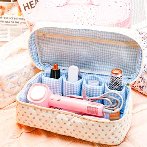 Quilted cosmetic storage bag with compartments for hair styling tools and accessories travel use.