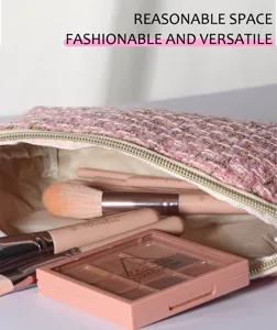 Pink tweed makeup bag detail featuring soft fabric texture, cosmetic brushes and eyeshadow.