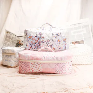 Quilted cosmetic bag detail showing soft patchwork floral pattern and sturdy zipper closure.