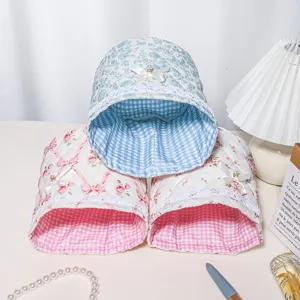 Detailed view of cute quilted fabric storage basket with lace trim, bow, and gingham lining.