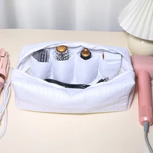 Detailed view of white padded hair styling tool organizer bag with multiple interior compartments.