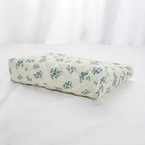 Quilted cosmetic bag detail showing blue floral pattern and soft padded fabric texture.