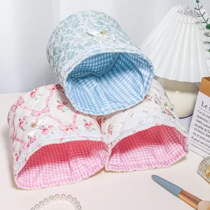 Close-up detail of quilted storage basket featuring cute bow and delicate lace trim.
