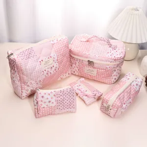 Detailed shot of pink quilted cosmetic bag set with charming patchwork floral and check patterns.