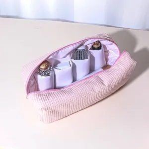 Pink padded waffle storage bag with multiple compartments for hair dryers and styling tools.