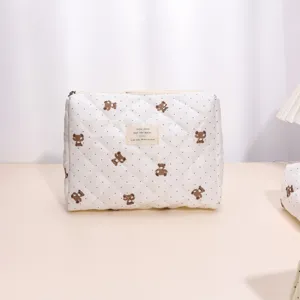 Detailed view of the quilted cosmetic pouch with cute bear pattern, soft fabric and smooth zipper.