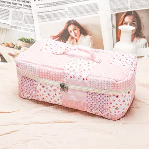 Quilted makeup bag with pink floral and plaid patchwork, portable travel storage pouch.