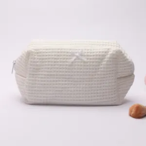 Close up of the white waffle cosmetic bag showing soft textured fabric and neat zipper detail.