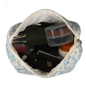 Quilted cosmetic bag with blue floral pattern, large capacity portable makeup storage pouch detail view.