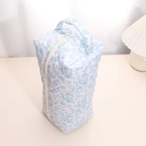 Detailed view of the quilted floral travel storage bag, showing the zipper and handle detail.