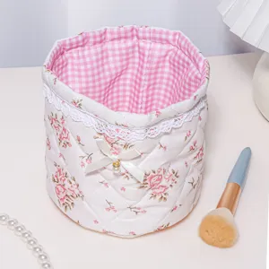 Detailed view of the cute quilted storage basket with pink floral print and bow decor.