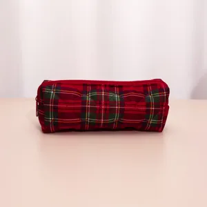 Detailed view of red plaid quilted makeup pouch, showing soft fabric texture and zipper.