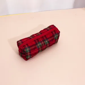 Red plaid quilted cosmetic bag detail, soft fabric texture with secure red zipper closure.