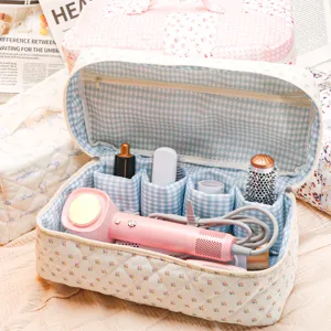Quilted floral makeup bag with blue gingham interior for hair styling tools travel storage.