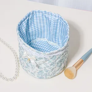 Quilted blue floral storage basket detail, cute desktop organizer with lace trim and bow.