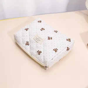 Quilted cosmetic bag detail showing cute brown bear print and soft cotton padding material.