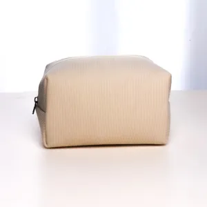 Close-up of beige corduroy travel toiletry pouch, showing detailed fabric texture and zipper.