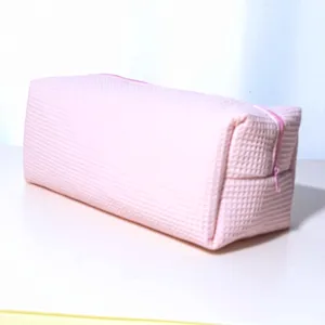 Pink waffle texture storage bag detail, portable zipper cosmetic organizer for daily use.
