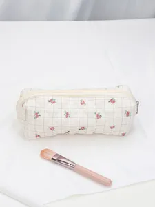 Quilted floral makeup bag detail, vintage grid pattern cosmetic pouch with durable zipper.