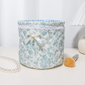 Cute quilted floral storage basket with lace trim and bow for desk organization and home decor.